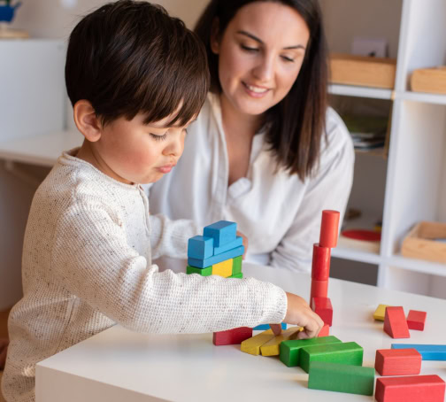 Autism Specialist in New Haven County, CT - 2 Autism specialist in New Haven County, CT supporting a child with hands-on learning blocks